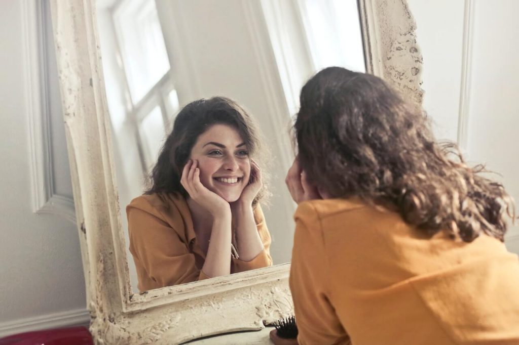 Woman smiling in front of mirror